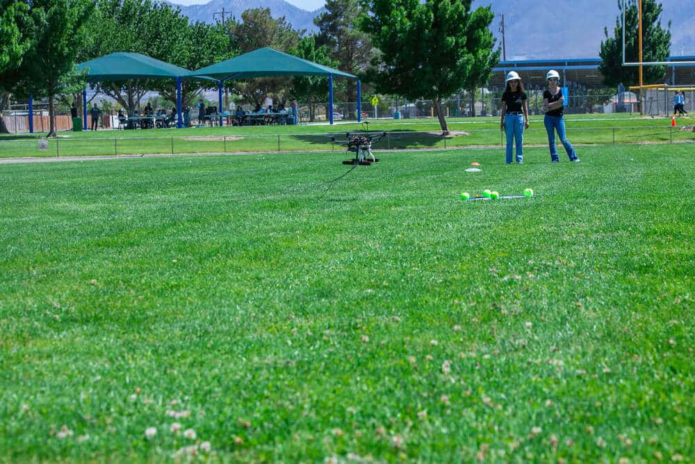 Two students flying a drone in a park for the Aerospace Robotics Competition