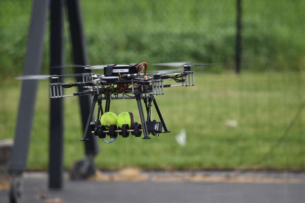 STEM-ED Aerospace Robotics Competition with drone flying and holding tennis balls